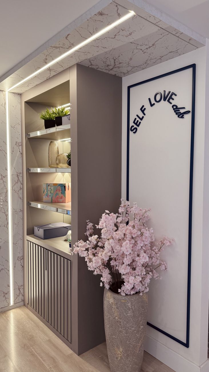 Corredor do consultório com o letreiro Self Love Club e flores