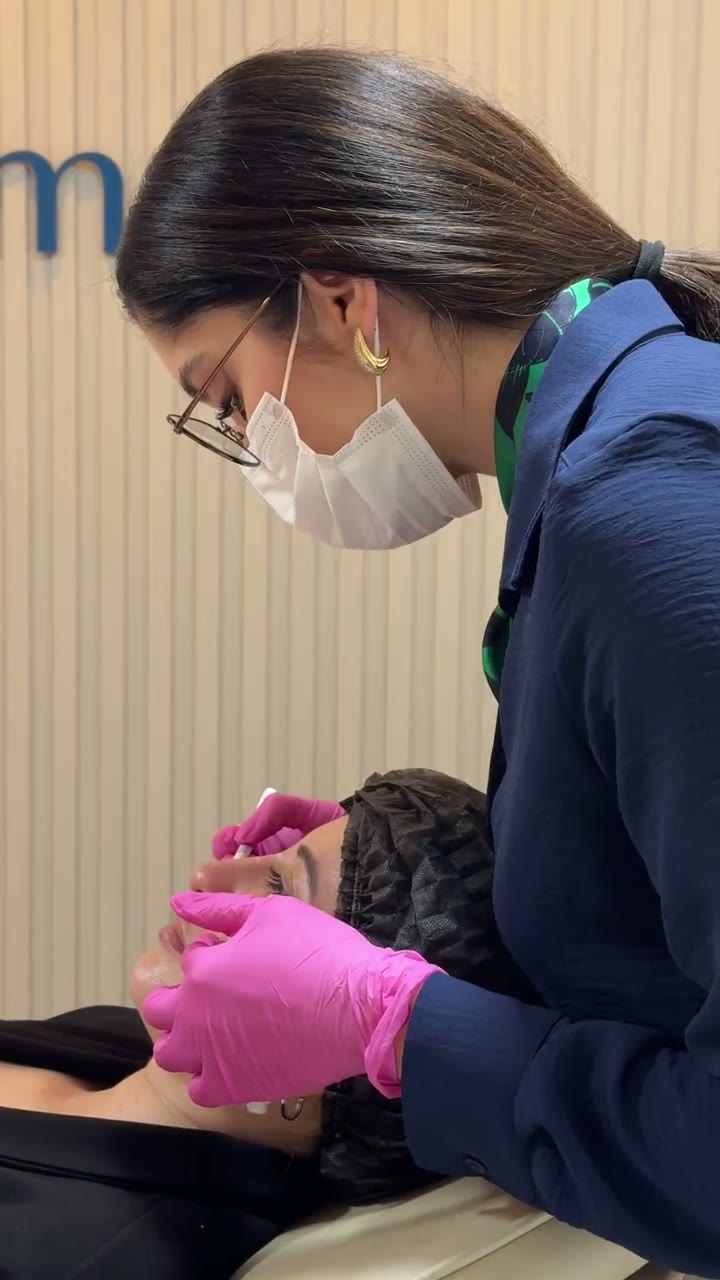 Dra. Beatriz fazendo a marcação no rosto de uma paciente antes do preenchimento