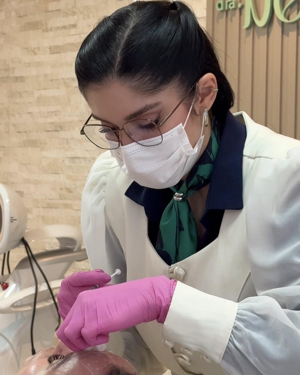 Dra. Beatriz Uthman aplicando toxina botulínica no rosto de uma paciente, com os pontos marcados na pele